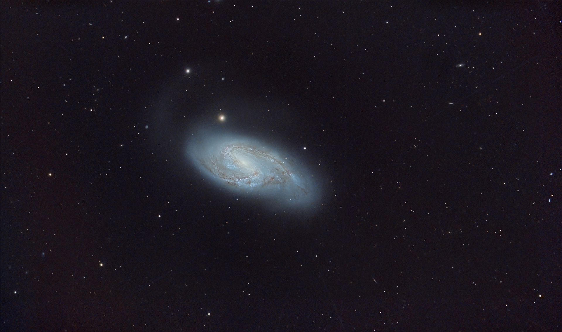 La gran galaxia espiral Messier 66 se encuentra a unos 35 millones de años luz. Tiene cerca de 100.000 años luz de diámetro, un tamaño similar al de nuestra galaxia, la Vía Láctea. Como dato adicional, en el año 2016 se observó una supernova en esta galaxia.