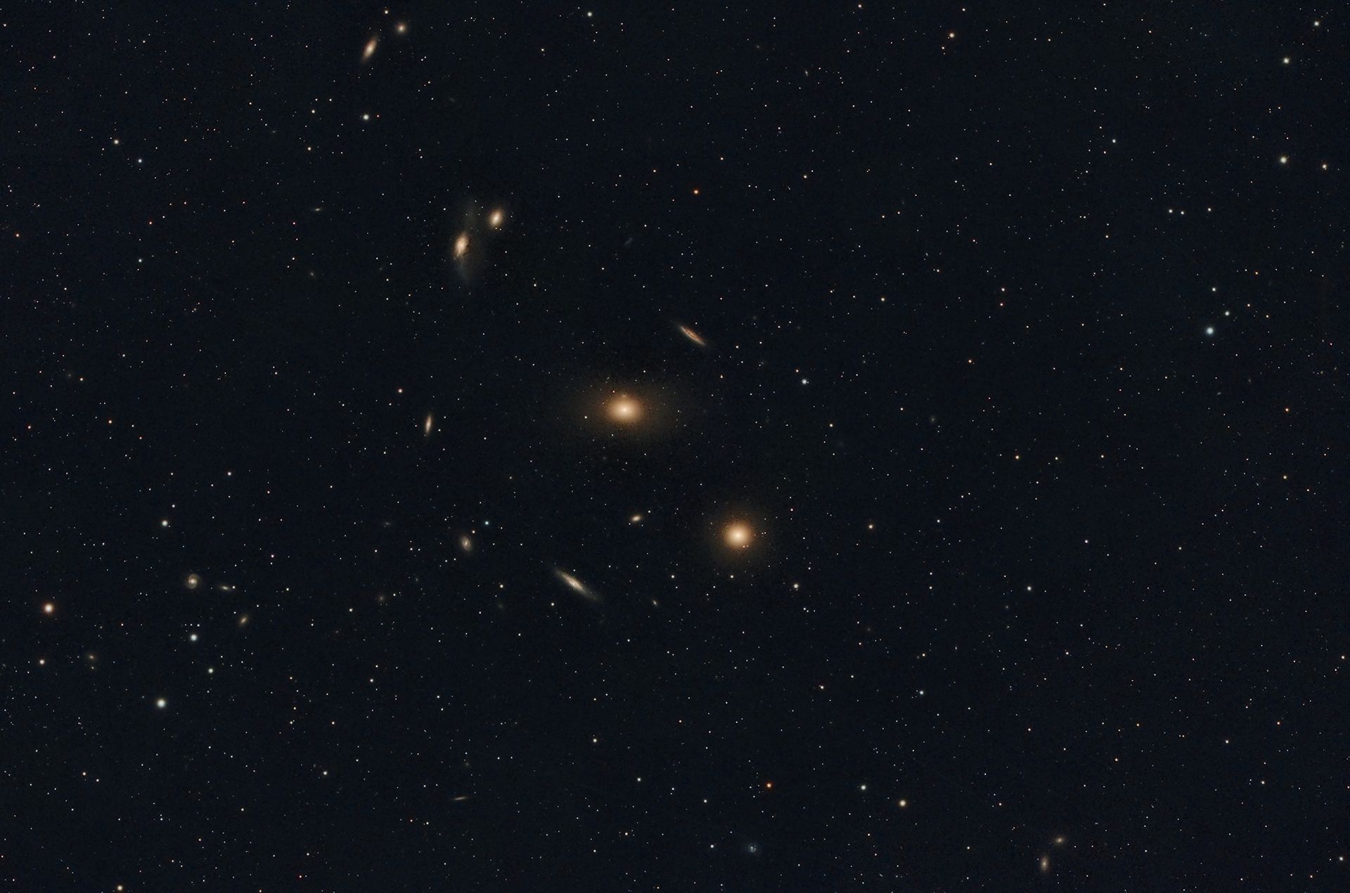Un pequeño sector del Cúmulo de Virgo. La imagen muestra una pequeña fracción de las galaxias que integran este inmenso cúmulo. Ubicado a una distancia de entre 55 y 60 millones de años luz de la Tierra, en la constelación de Virgo. En total, el cúmulo contiene entre 1.300 y 2.000 galaxias y constituye el núcleo del Supercúmulo Local, cuya gravedad influye sobre nuestro Grupo Local de galaxias, donde se encuentra la Vía Láctea.